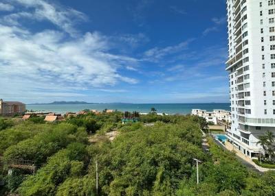 Scenic view from a high-rise apartment overlooking a coastal area with greenery and buildings