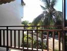 View from the balcony featuring railing with a view of palm trees and a clear sky