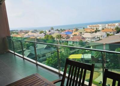 Spacious balcony with seating overlooking a residential area and the ocean