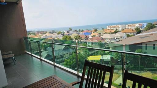 Spacious balcony with seating overlooking a residential area and the ocean