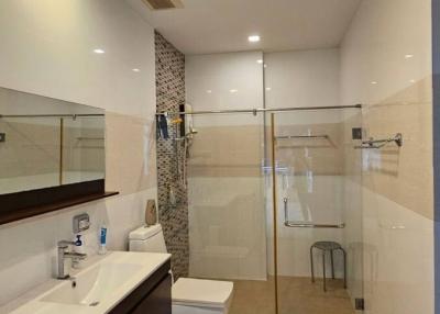 Modern bathroom interior with glass shower and white appliances