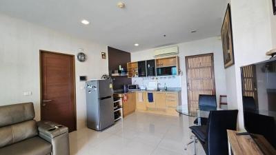 Spacious combined living room and kitchen with modern appliances and comfortable seating