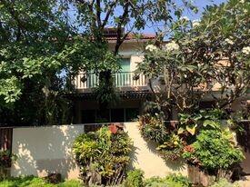 Cozy suburban house with a lush garden and balcony