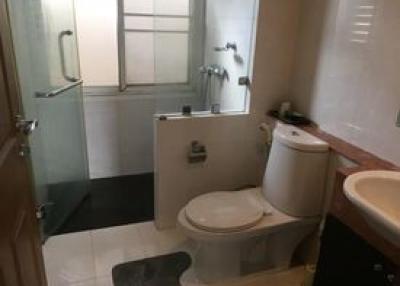 Compact bathroom with a toilet, sink, and shower