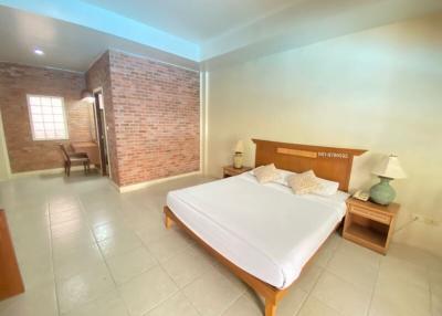 Spacious bedroom with brick wall features and ample natural lighting