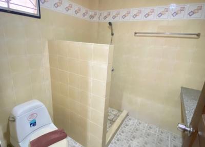 Small bathroom with beige tiles and shower area