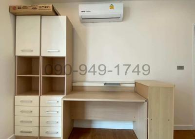Bright and clean bedroom with built-in workspace and air conditioning unit