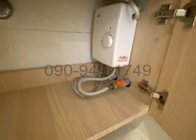 Compact bathroom water heater unit mounted under a cabinet