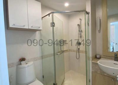Modern bathroom interior with glass shower, toilet, and basin