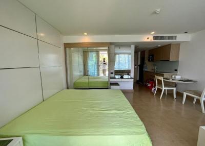 Bright modern studio bedroom with integrated kitchen and mirrored wardrobe