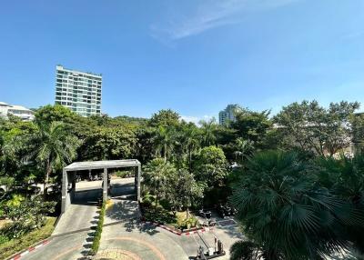 Scenic view of the gated entrance to a residential community with lush greenery under a clear blue sky