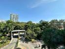 Scenic view of the gated entrance to a residential community with lush greenery under a clear blue sky