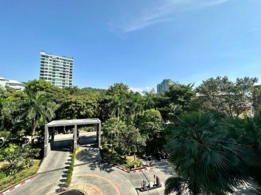 Scenic view of the gated entrance to a residential community with lush greenery under a clear blue sky