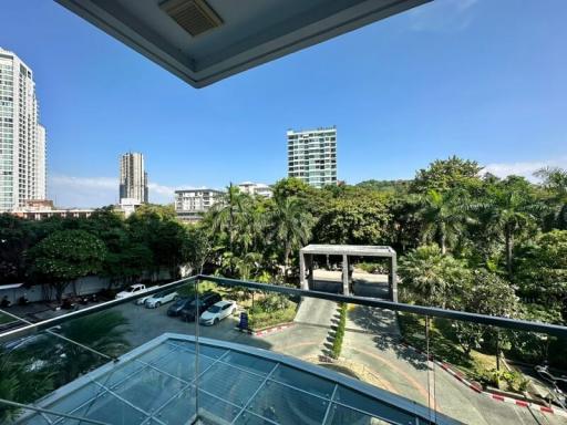 Spacious balcony with a view of the city skyline and greenery