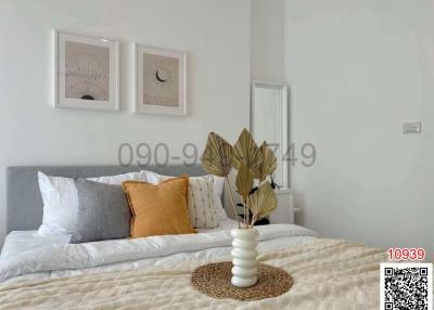 Modern bedroom with a neatly made bed and wall art