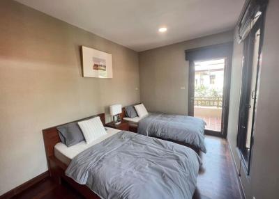 Spacious bedroom with twin beds and balcony access