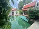 Lush garden with a swimming pool and traditional building architecture