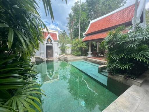 Lush garden with a swimming pool and traditional building architecture