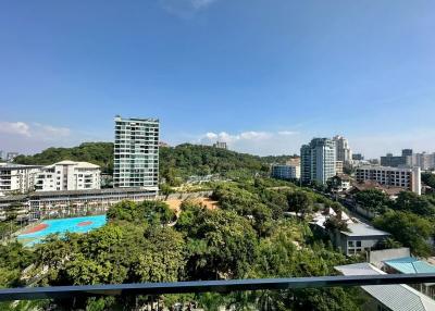 Panoramic view from a balcony overlooking a residential area with pool and greenery