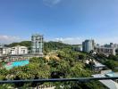 Panoramic view from a balcony overlooking a residential area with pool and greenery