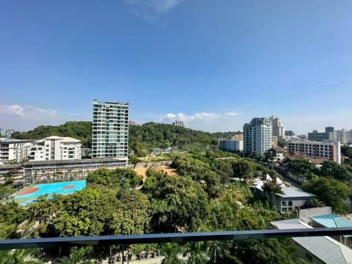 Panoramic view from a balcony overlooking a residential area with pool and greenery