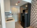 Compact modern kitchen with built-in appliances and textured wall design
