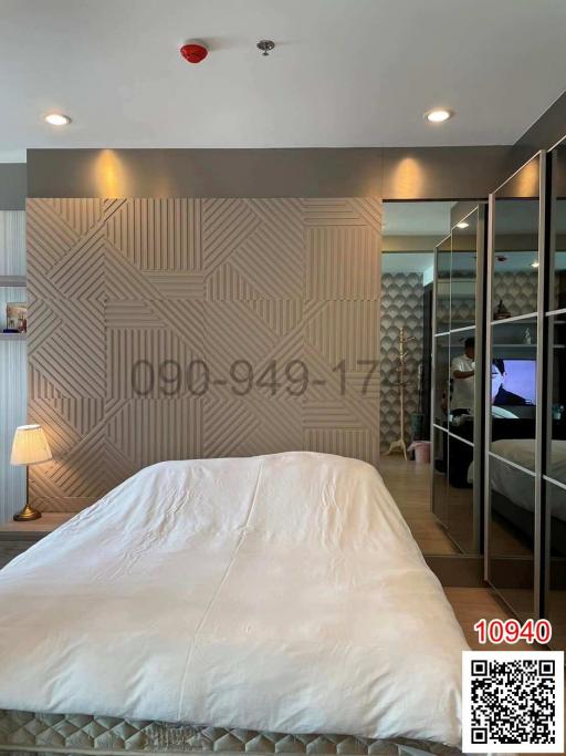 Contemporary bedroom with patterned wall and mirrored closet doors