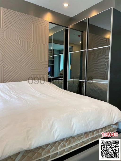 Modern bedroom with textured headboard and mirrored wardrobe