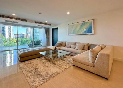 Modern living room with large sectional sofa and sliding doors leading to a balcony