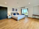 Spacious bedroom with ocean view, natural light, and hardwood flooring