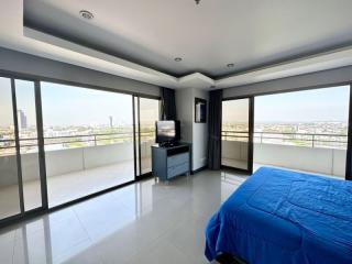 Spacious bedroom with large windows and city view