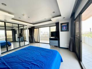 Spacious bedroom with large windows and city view