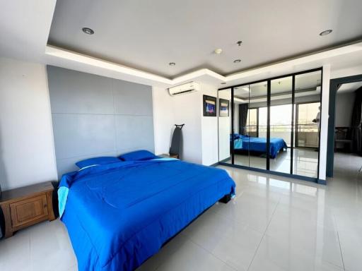 Spacious bedroom with large bed and mirrored wardrobe doors