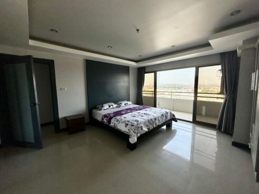 Spacious bedroom with large windows and city view