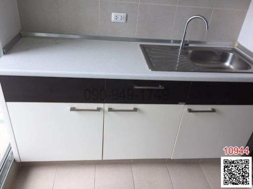 Compact kitchen with white cabinets and stainless steel sink