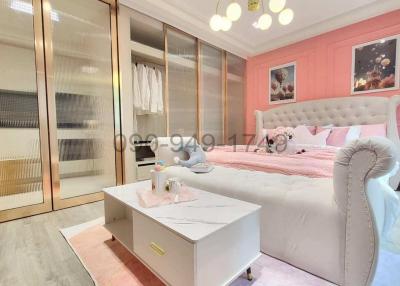 Spacious bedroom with a large bed, wardrobe, and warm lighting