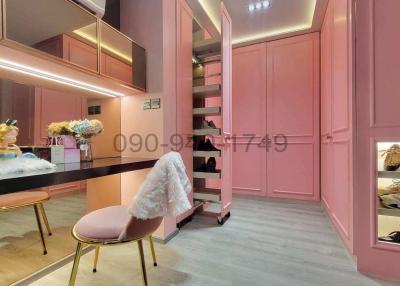 Elegant walk-in wardrobe with pink cabinetry and ambient lighting