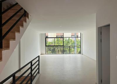 Spacious and bright living room with large windows and staircase