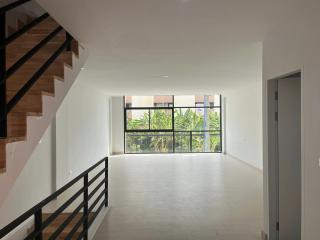 Spacious and bright living room with large windows and staircase