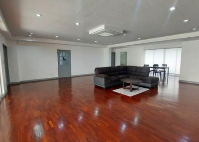 Spacious living room with glossy hardwood floors and modern lighting