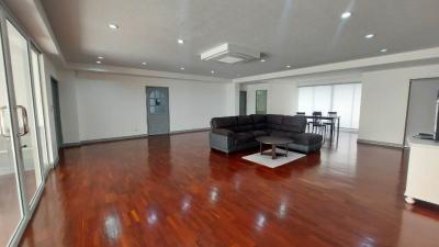 Spacious living room with glossy hardwood floors and modern lighting