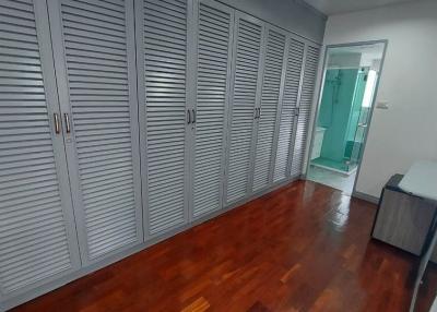 Spacious bedroom with large built-in wardrobes and wooden flooring