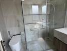 Modern bathroom with glass shower enclosure and ceramic fixtures