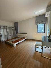 Spacious unfurnished bedroom with hardwood floors and built-in storage