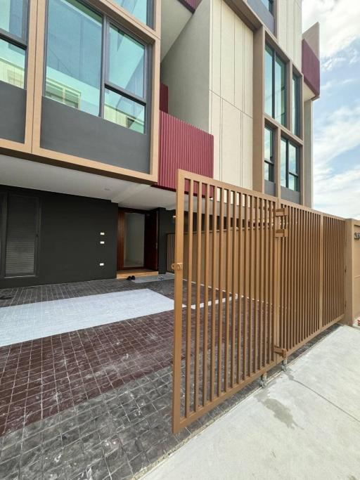 Modern townhouse exterior with large windows and secure fencing