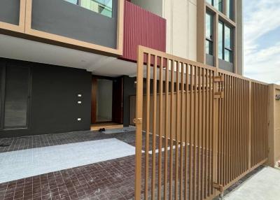 Modern townhouse exterior with large windows and secure fencing