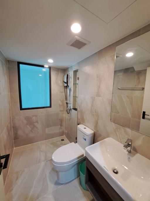Modern bathroom interior with walk-in shower, toilet, and sink