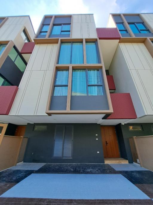 Modern townhouse exterior with red and beige facade