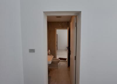 Hallway leading to rooms with wooden doors and ceramic tile flooring
