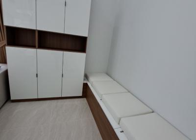 Cozy bedroom with large wardrobe and cushioned bench